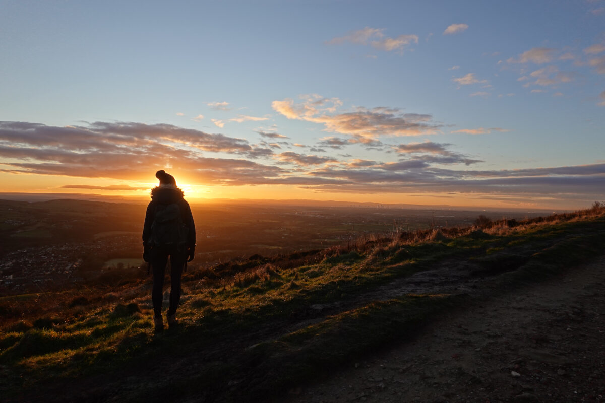 Girl overlooking sunrise in countryside setting