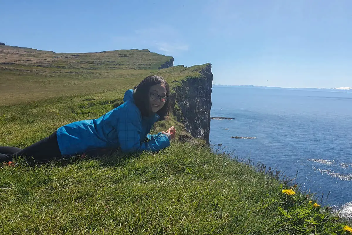 Girl lay on clifftop in Iceland